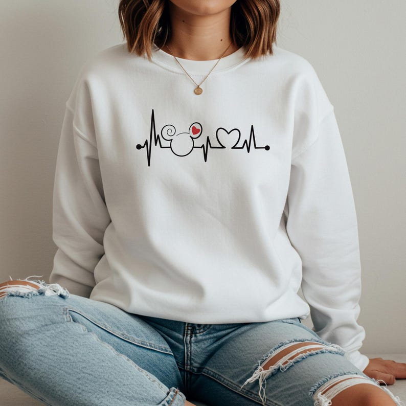 May include: White sweatshirt with a black and red graphic of a Mickey Mouse head with a heart inside one ear. The graphic is a heartbeat line with the Mickey Mouse head in the middle.