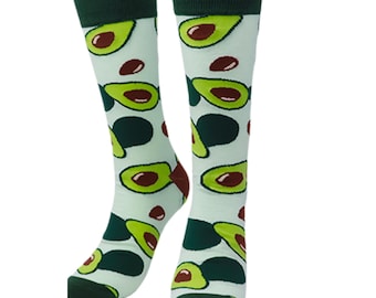 May include: A pair of knee-high socks with a light green background and a repeating pattern of avocados. The avocados are green with brown pits and dark green accents. The top and toe of the socks are dark green.