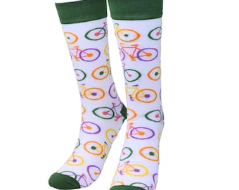 May include: A pair of white knee-high socks with a repeating bicycle pattern in purple, orange, yellow, and green. The socks have green cuffs and toes. The bicycle design includes the wheels and frame.
