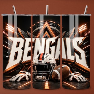 Puede incluir: Un vaso cilíndrico con pajita que presenta un gráfico de un casco de fútbol americano blanco con rayas naranjas y negras, un balón de fútbol americano marrón y guantes blancos. El fondo muestra la palabra BENGALS en letras blancas grandes.