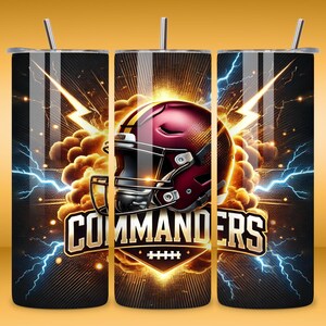 May include: A black and gold tumbler with a football helmet and the word "Commanders" in gold letters. The helmet is red and gold with a white face mask. There are lightning bolts and clouds in the background.