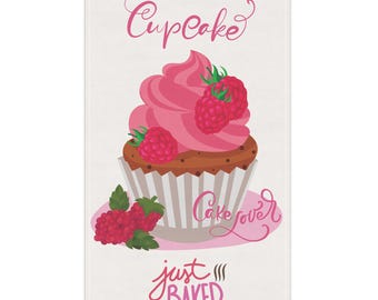 May include: A white rectangular towel featuring a cupcake illustration. The cupcake has pink frosting and is topped with raspberries. Text includes "Cupcake", "Cake lover", and "just baked" in pink script.