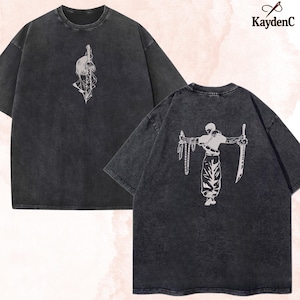 Puede incluir: Dos camisetas gris carb&oacute;n con dise&ntilde;os gr&aacute;ficos blancos. Una camiseta presenta un dise&ntilde;o de espada y pluma, la otra un guerrero con una espada y una cadena. La marca "KaydenC" est&aacute; en la esquina superior derecha.
