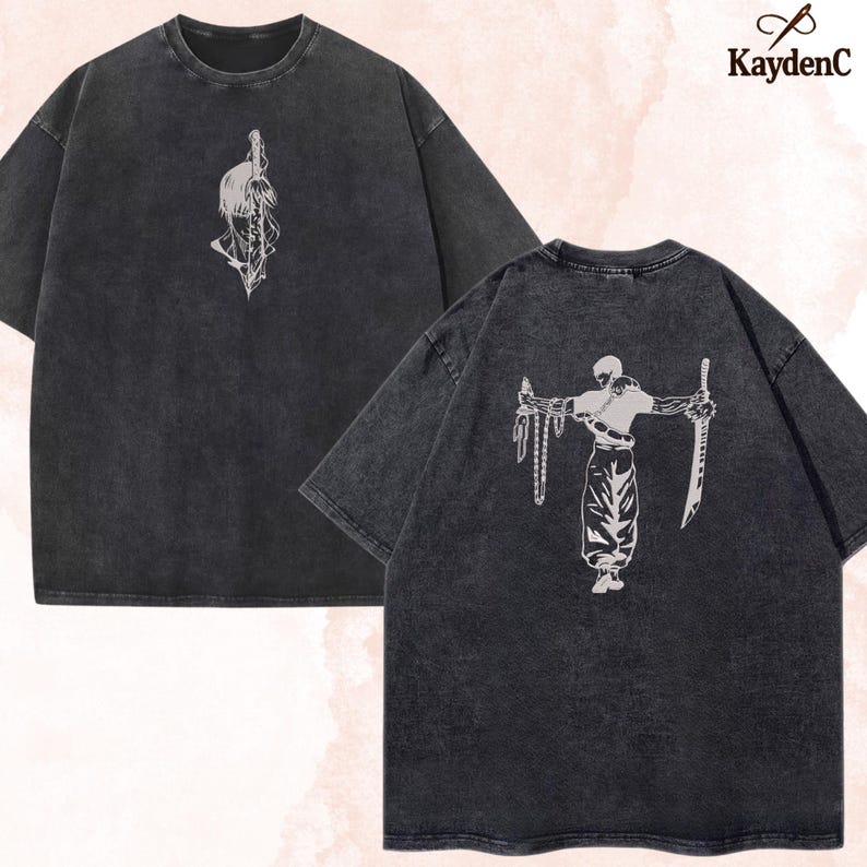 Puede incluir: Dos camisetas gris carb&oacute;n con dise&ntilde;os gr&aacute;ficos blancos. Una camiseta presenta un dise&ntilde;o de espada y pluma, la otra un guerrero con una espada y una cadena. La marca "KaydenC" est&aacute; en la esquina superior derecha.