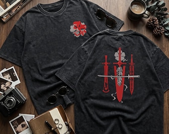 May include: A charcoal gray acid-wash t-shirt featuring a small red and white clover graphic on the front chest and a large back print displaying three red swords, a central feather, and a horizontal silver katana blade.