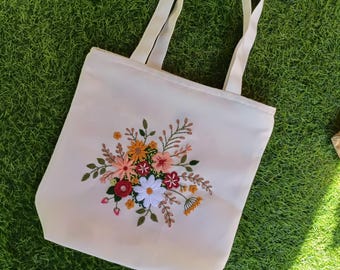 Borsa tote in tela con ricami floreali e cerniera.