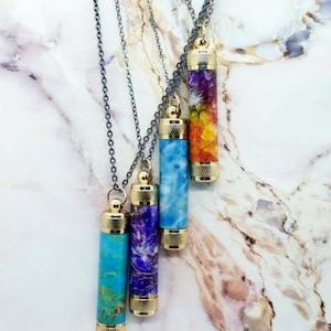 Op de afbeelding: Vier halskettingen met gouden sluitingen en verschillende gekleurde hars hangers. De hangers zijn gevuld met kleurrijke bloemen, swirls en turquoise.
