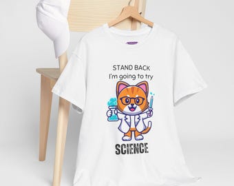 Op de afbeelding: Wit T-shirt met een cartoonkat die een bril en een labjas draagt en een bekerglas en een pipet vasthoudt. De tekst "Stand Back I'm going to try Science" is op het T-shirt gedrukt.