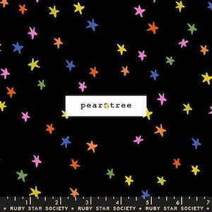 May include: Black fabric with a scattered pattern of colorful stars in shades of pink, yellow, orange, green, and blue. The text "pear tree" is in a white rectangle. The fabric is from Ruby Star Society.