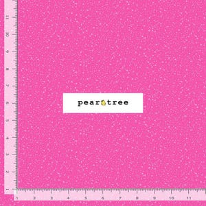 May include: Bright pink fabric with a speckled pattern and a white rectangle with the text "pear tree" and a pear graphic. The fabric has a ruler along the edges.