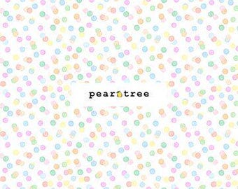May include: White fabric with a repeating pattern of pastel-colored polka dots. The dots are in shades of pink, blue, green, and yellow. The text "pear tree" is in the center of the fabric. A ruler is at the bottom.