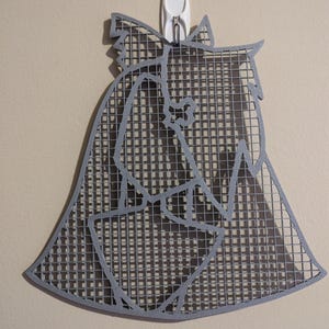 May include: A gray metal wall decor in the shape of a dog's head. The metal is cut out in a grid pattern, creating a shadow effect.