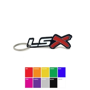 May include: A black, white, and red LSX keychain. The keychain features the text "LSX" in white with a red "X" design. The keychain is attached to a silver metal ring.