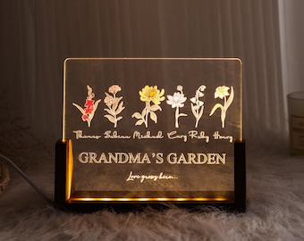 May include: A wooden framed light-up sign with a clear acrylic panel featuring a floral design and the text "Grandma's Garden, Love grows here..." with names listed below the flowers.