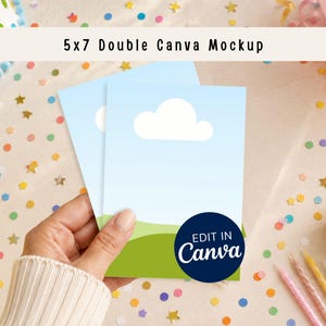 Può includere: Un mockup Canva doppio 5x7 con due biglietti con un design di cielo blu e nuvole, tenuti in mano. I biglietti sono su una superficie festosa con coriandoli, un cupcake e decorazioni per feste. Il logo Canva è visibile.