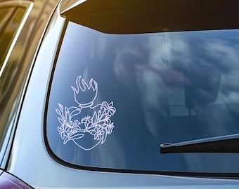 May include: White vinyl decal featuring a stylized heart with a flame at the top and floral accents. The decal is applied to the rear window of a vehicle, showcasing a clean, minimalist design.