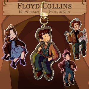 Peut inclure: Plusieurs porte-clés en acrylique avec des illustrations de personnages de dessins animés. Les porte-clés ont un fermoir doré et une enseigne en bois avec l'inscription "Floyd Collins Keychain Preorder". Les personnages sont dans diverses poses.