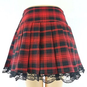 Women's Plaid Pleated Skirt | Contrast Vintage Y2k Clothes | Gothic Harajuku Fashion
.
Woman wearing a plaid pleated mini skirt styled with gothic accessories and layered outfit, showcasing Y2K Harajuku streetwear fashion.