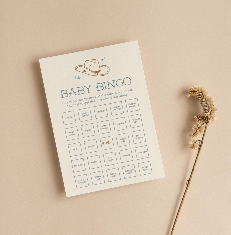 May include: A beige baby shower bingo card with a blue cowboy hat illustration at the top. The card has a grid of 25 squares with baby-related items listed in each square, such as onesie, baby powder, wipes, bottle warmer, diaper cream, high chair, crib sheets, pacifier, musical toy, hat, bottle, free, sippy cup, baby monitor, bouncer, socks, car seat, stroller, swaddle, stuffed animal, diaper bag, baby book, changing pad, and burp cloth.