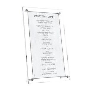 May include: Clear acrylic sign with Hebrew text and English translations, featuring a list of symbolic foods for Rosh Hashanah. The sign is held together with silver-colored hardware and has a decorative border.