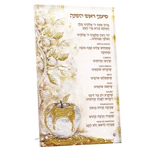 May include: A decorative glass panel with gold accents and Hebrew text. The panel features an embossed apple and tree design. The text includes blessings and symbols associated with Rosh Hashanah, the Jewish New Year.