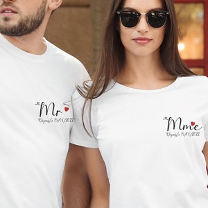 Peut inclure: Un couple portant des t-shirts blancs avec le texte "Mr." et "Mme." et un petit cœur rouge. Le texte comprend également la date "August 13, 2022".