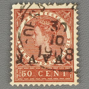 May include: A red vintage postage stamp from the Dutch East Indies, featuring a profile of a woman wearing a crown. The stamp has black text and a face value of 50 cents. The year 1918 is visible.