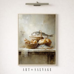 Puede incluir: Pintura enmarcada de naturaleza muerta que representa una mesa rústica con cestas de pan, huevos y pescado. La obra de arte tiene una paleta de colores apagados con tonos beige, marrón y gris. El texto "ART & SALVAGE" está en la parte inferior del marco.