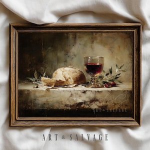 Puede incluir: Pintura enmarcada de naturaleza muerta con pan, vino tinto en una copa y follaje. La obra de arte tiene un estilo vintage con una paleta de colores oscuros y apagados. El texto "ART & SALVAGE" es visible en la parte inferior.