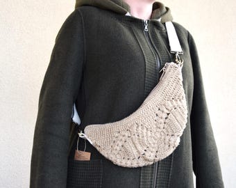 Sac banane beige crocheté à la main en laine certifiée GOTS ; son achat soutient un projet pour les femmes en Inde.