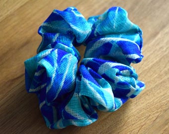 Un chouchou bleu confectionné à partir de saris recyclés — bleu foncé, bleu clair, blanc — apporte les couleurs vibrantes de l'Inde dans votre vie.