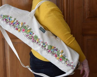 Sac de tapis de yoga brodé à la main, issu d'une production équitable, orné de broderies au ruban de soie et fabriqué en coton biologique certifié GOTS. Ce sac soutient un projet destiné aux femmes en Inde.
