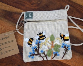 Pochette poitrine beige pour enfant, brodée d'abeilles et de fleurs, en jute et coton certifié GOTS. Soutient un projet en faveur des femmes.