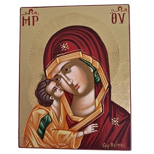 May include: A religious icon depicting the Virgin Mary and the Christ Child. The figures are painted in warm tones of red, gold, and orange, with the Virgin Mary wearing a dark red veil. The background is gold with religious text.