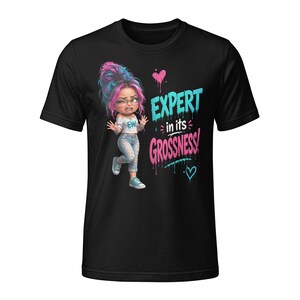 May include: A black short-sleeved t-shirt featuring a cartoon character with pink and blue hair, wearing a white top and distressed jeans. The graphic includes the text "EXPERT in its GROSSNESS!" in blue and pink, along with small heart icons.