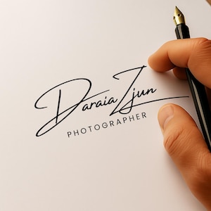 Può includere: Una penna stilografica nera tenuta da una mano sopra un foglio di carta bianco. La carta presenta una firma in elegante corsivo, che recita "Daraia Zun" con "PHOTOGRAPHER" sotto.