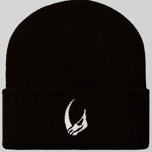 May include: Black beanie with a white embroidered crescent moon design.