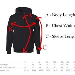 Puede incluir: Una sudadera con capucha negra con una tabla de tallas que muestra las medidas de la longitud del cuerpo, el ancho del pecho y la longitud de la manga en pulgadas.