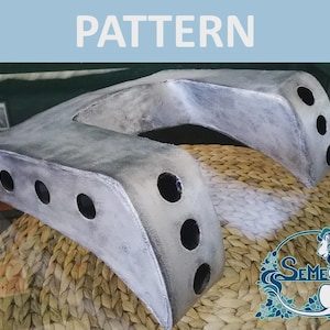 May include: A gray, U-shaped, molded plastic piece with multiple holes. The piece is sitting on a woven wicker surface.