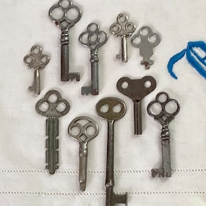 May include: A collection of ten antique skeleton keys with intricate designs. The keys are made of metal and have a silver finish.