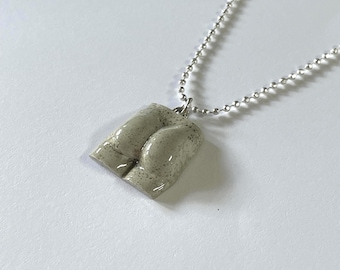 Collana con ciondolo a forma di mattonella di cemento realizzata a mano, finitura laccata, un accessorio perfetto per avviare una conversazione.