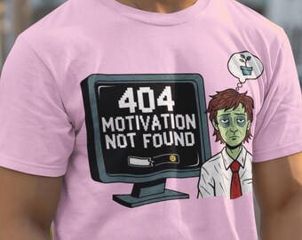 May include: A light pink t-shirt featuring the text "404 Motivation Not Found" on a computer screen graphic. A cartoon character with a thought bubble of a plant is next to the screen. The person is wearing white pants.