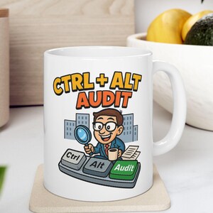 Può includere: Tazza in ceramica bianca con la scritta "CTRL + ALT AUDIT" in giallo e arancione. La tazza presenta un'illustrazione a cartoni animati di una persona che tiene in mano una lente d'ingrandimento, con tasti della tastiera ed edifici della città sullo sfondo.