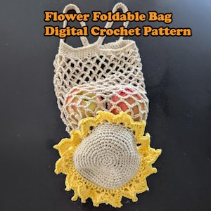 May include: A crocheted flower-shaped bag with a mesh design. The bag is folded and has a yellow crocheted flower on top. The bag is filled with apples.