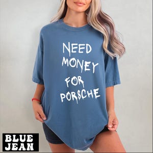 a blonde woman wearing a blue shirt that says need money for porsche