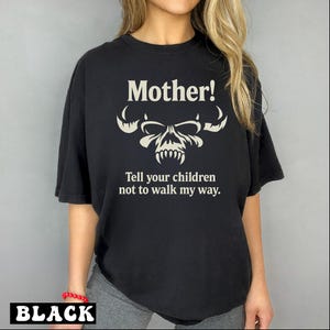 May include: Black t-shirt with a white skull graphic and the text "Mother! Tell your children not to walk my way."