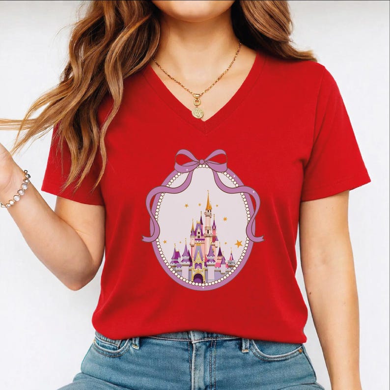 A woman wearing a red t-shirt with a castle graphic and a purple ribbon design.