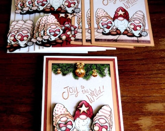 May include: Christmas greeting cards with gnome illustrations. The cards feature the phrase "Joy to the World!" on a white background, decorated with festive elements like baubles and greenery. The gnomes wear red and beige hats.