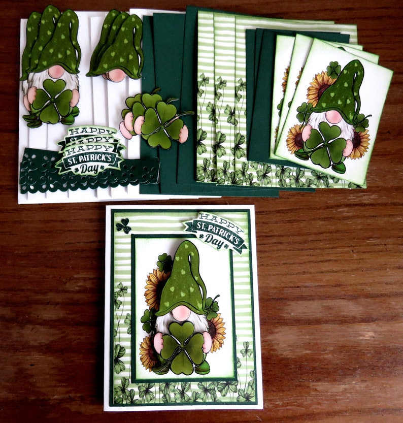 May include: A collection of St. Patrick's Day themed paper crafts. The image features a greeting card with a gnome holding a four-leaf clover, surrounded by sunflowers. Additional elements include cut-out gnomes, clovers, and cards with striped and floral patterns. The phrase "Happy St. Patrick's Day" is visible.