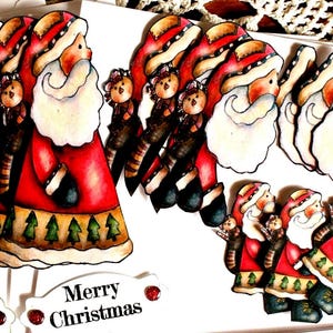 Op de afbeelding: Een verzameling uitgestanste papieren kerstmanfiguren met rode jassen met groene boompatronen, witte baarden en kleine dierenaccenten. Witte rechthoekige labels met de gedrukte tekst Merry Christmas zijn in de set inbegrepen.